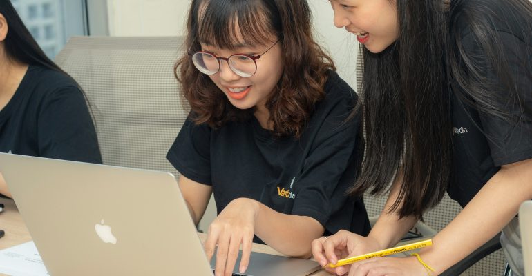 Benefits of Professional Transcription for Academic Research - Two female students in front of a laptop